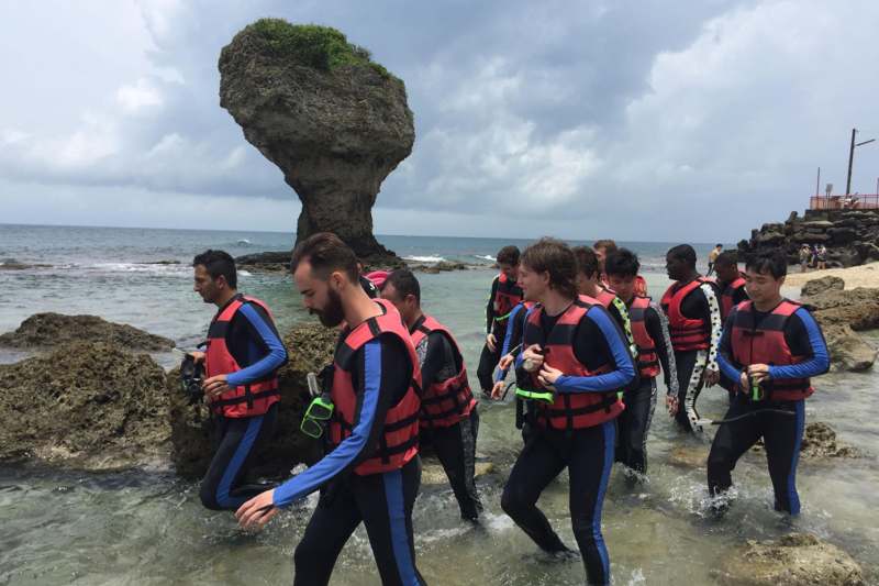a group of people in life jackets walking in the water