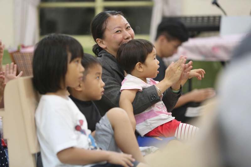 a woman and children clapping