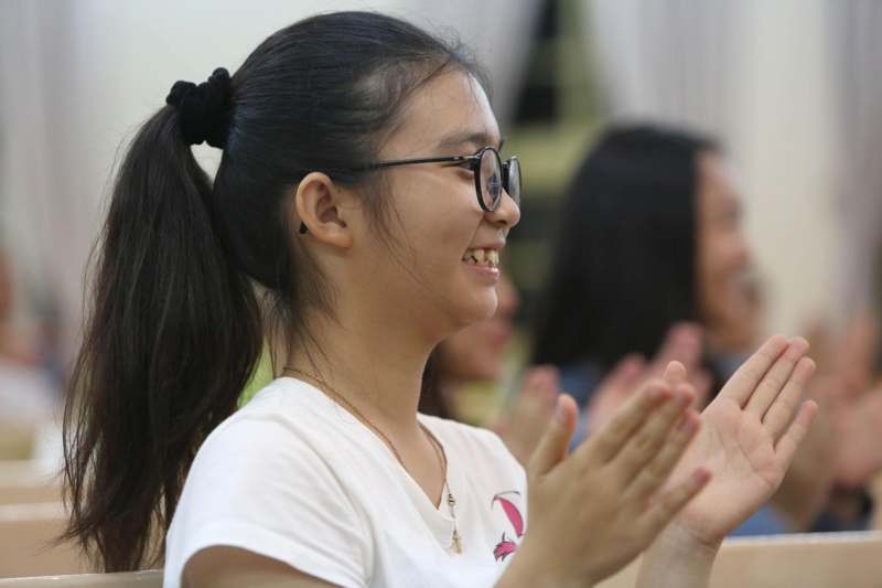 a girl with ponytail wearing glasses and smiling