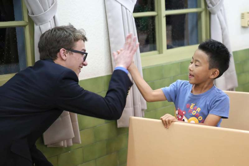 a man giving a boy a high five