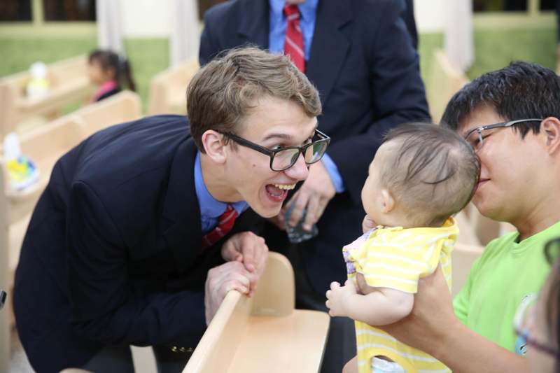 a man in a suit and tie holding a baby