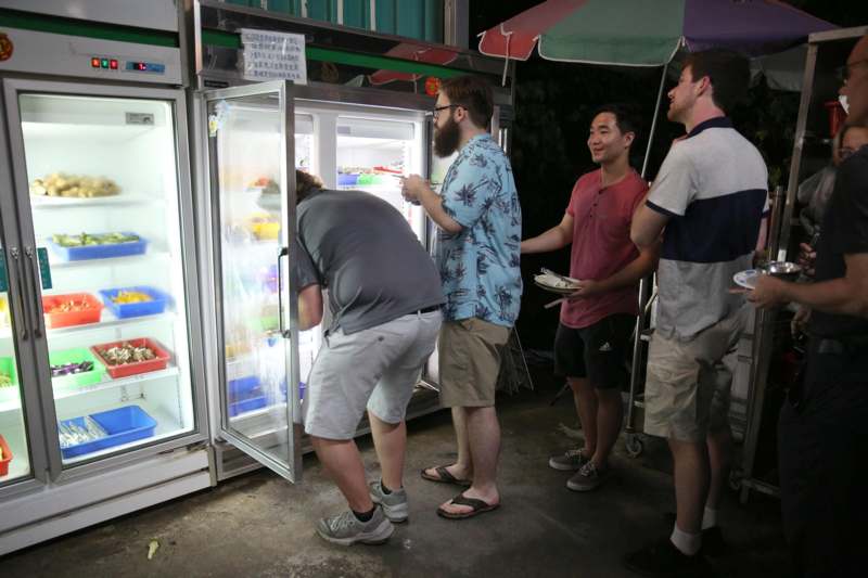 a group of men looking at a refrigerator