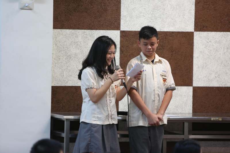 a boy and girl in uniform holding a microphone