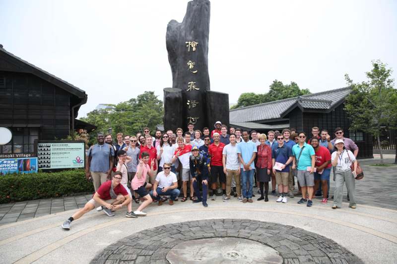 a group of people posing for a photo in front of a large statue