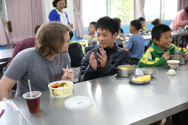 a man and boy sitting at a table with food in bowls