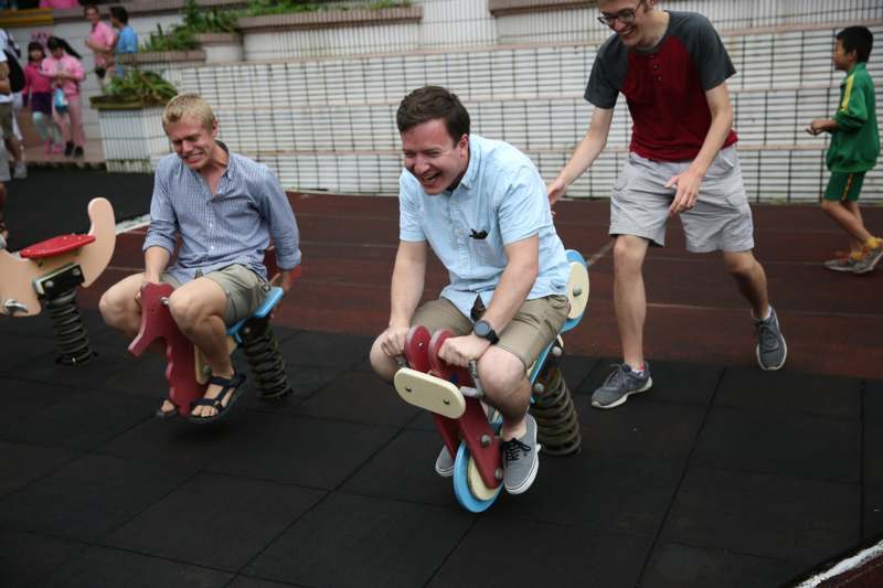 a group of men riding on a toy rocking horse