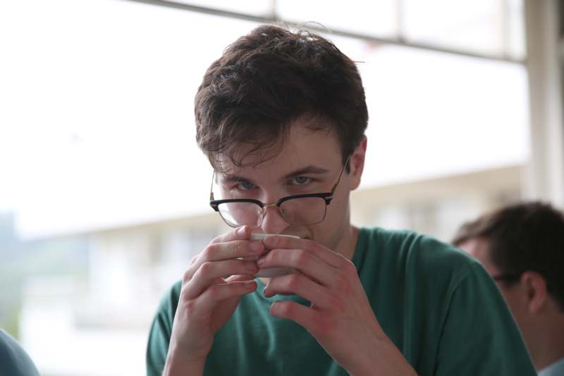 a man in glasses holding a cup
