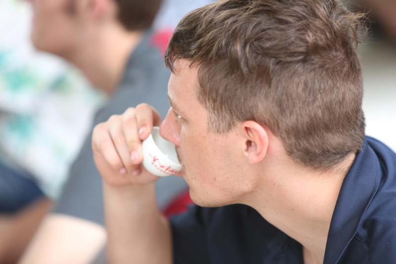 a man drinking from a small cup