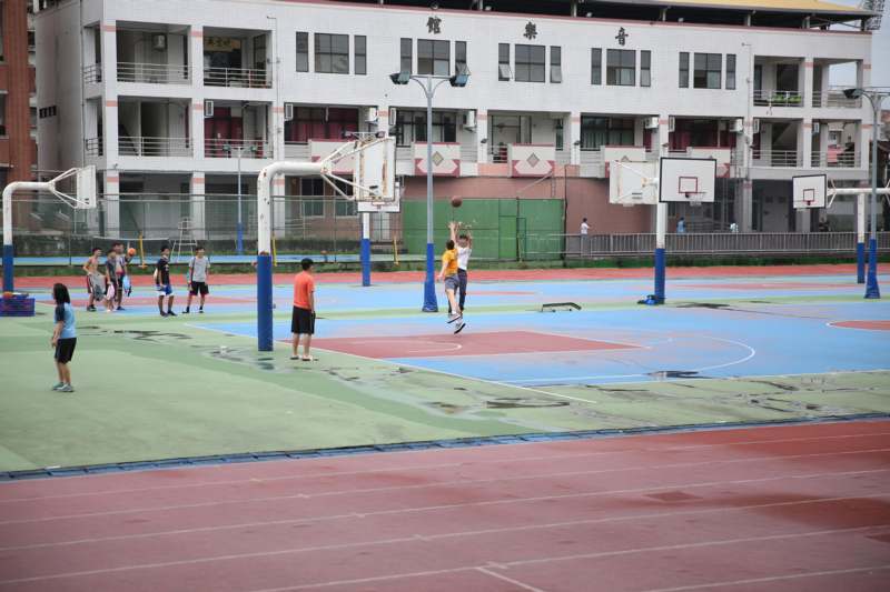 a group of people playing basketball on a court