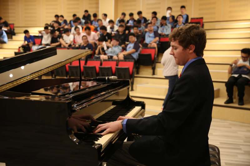 a man playing a piano in front of a group of people