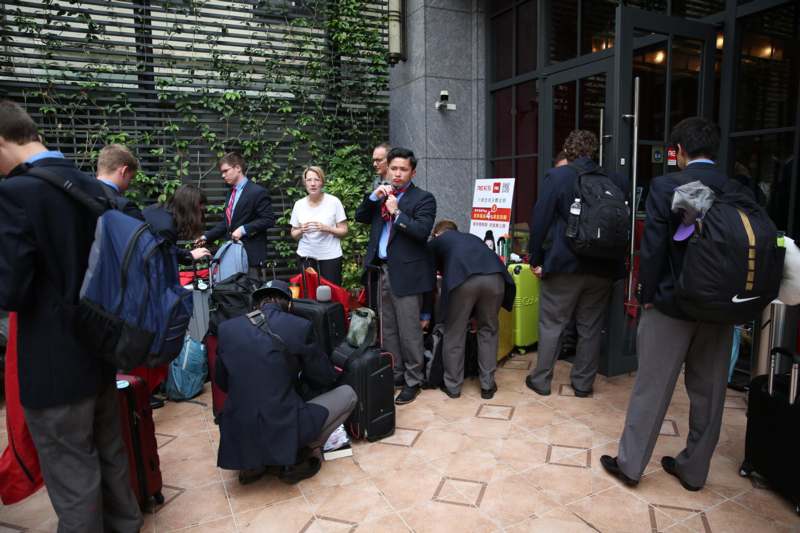 a group of people outside a building with luggage