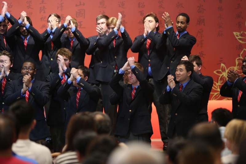 a group of people in suits clapping
