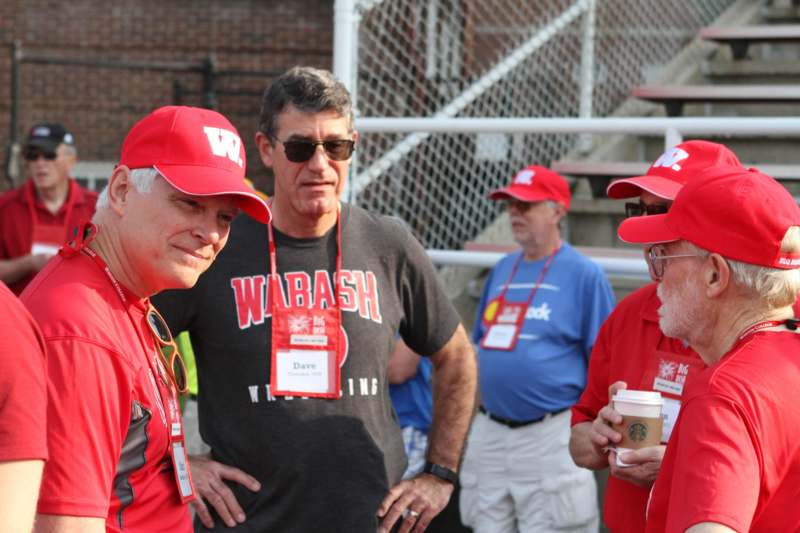 a group of men wearing red hats and lanyards