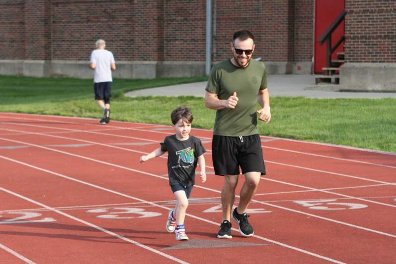 a man and child running on a track