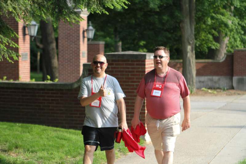two men walking on a sidewalk