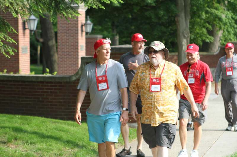 a group of men walking on a path with red hats
