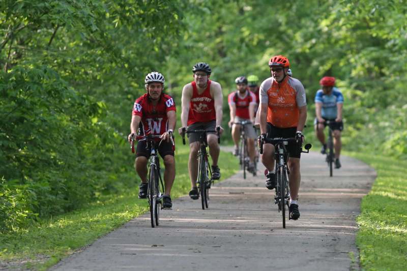 a group of people riding bicycles on a path