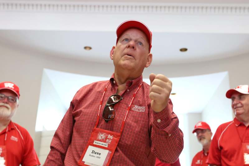 a man wearing a red hat and a red shirt with a name tag
