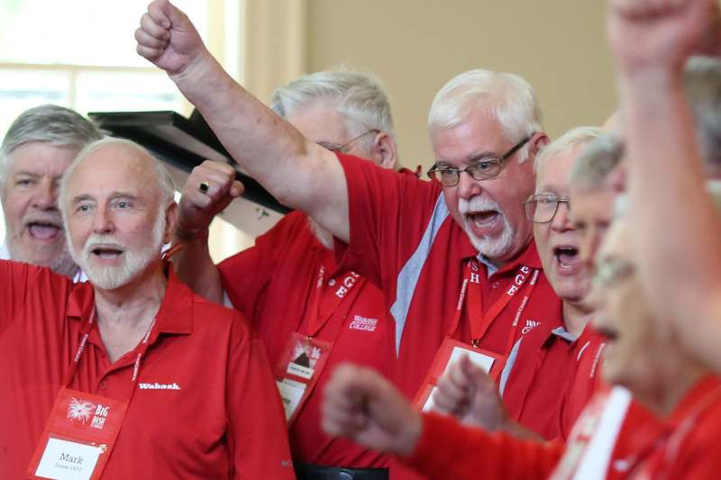 a group of older men wearing red shirts