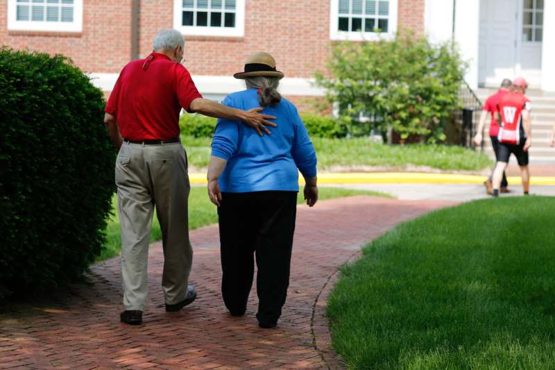 a man and woman walking down a brick path