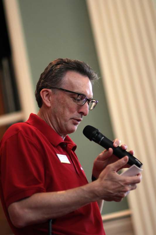 a man in a red shirt holding a microphone
