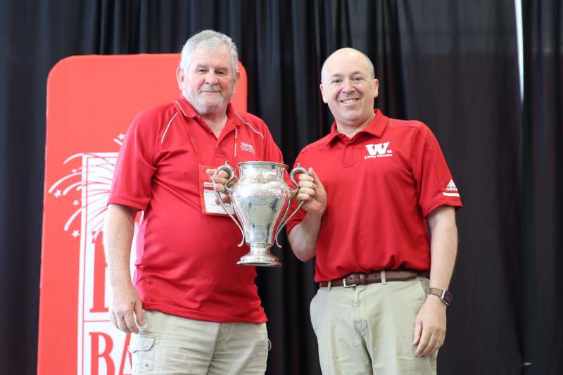 two men holding a trophy