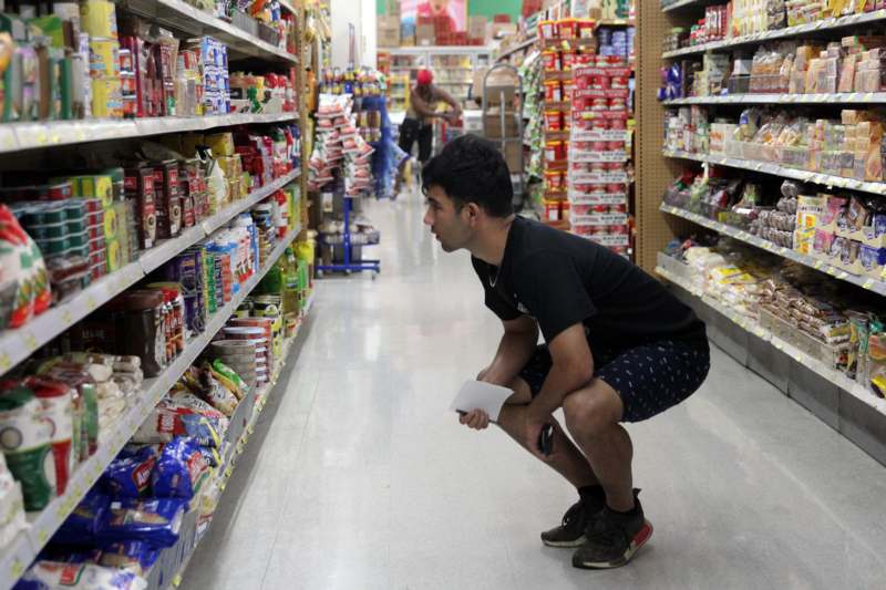 a man squatting in a store