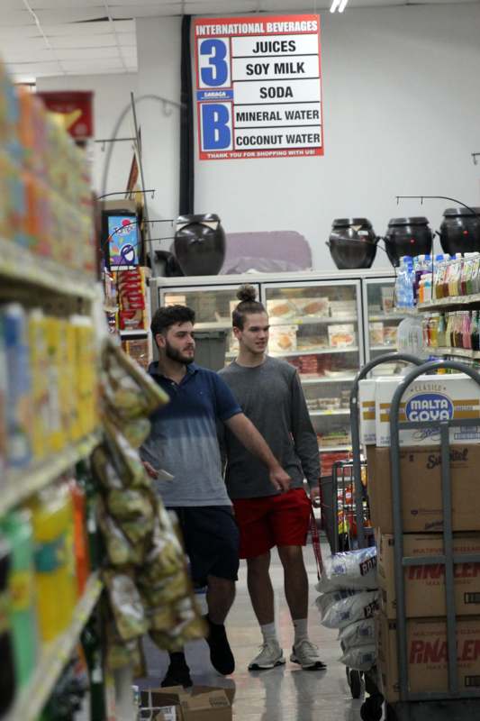 two men walking in a grocery store
