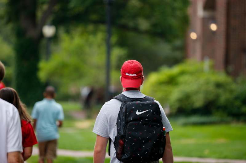 a man wearing a backpack and red hat