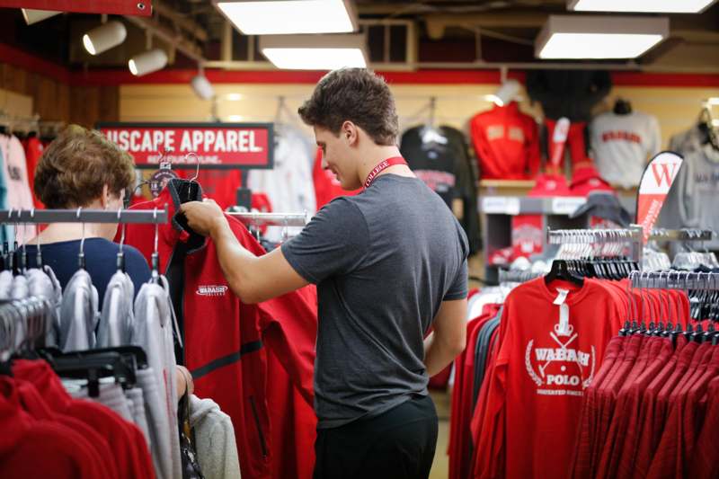 a man looking at a red shirt