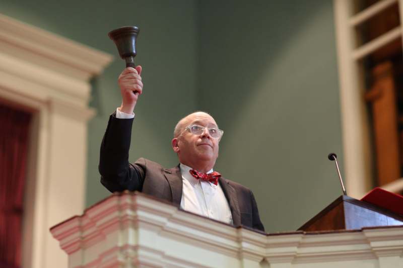 a man holding a bell