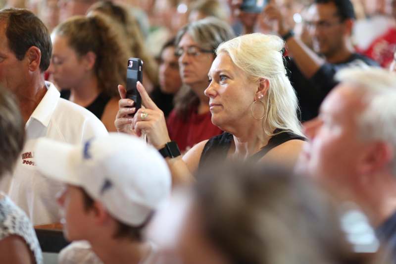 a woman holding a phone in a crowd