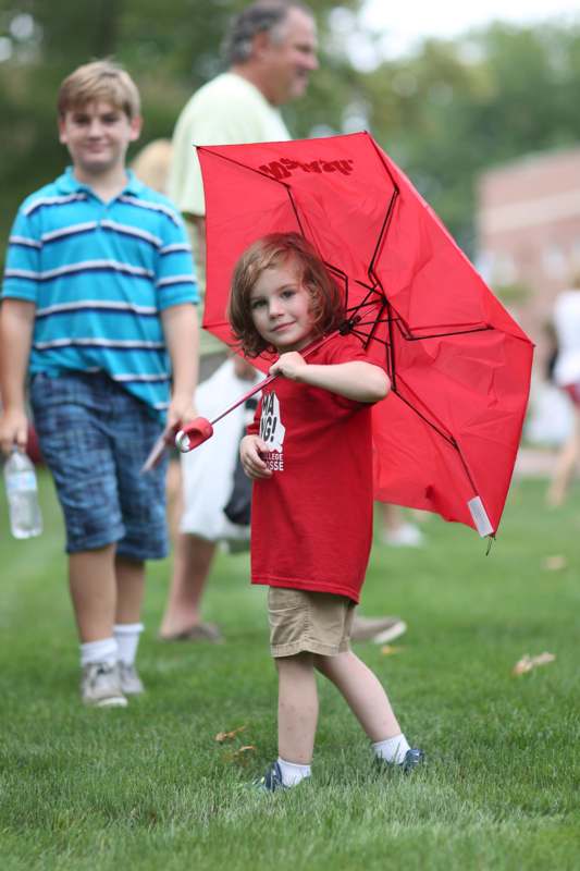 a boy holding a red umbrella