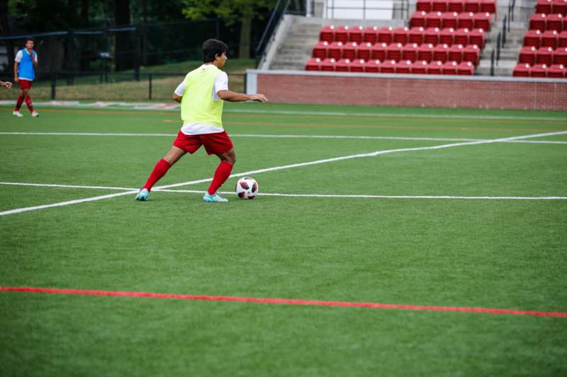 a boy kicking a football ball on a field