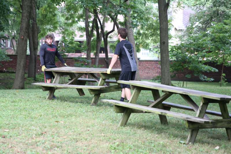 two men standing next to a picnic table