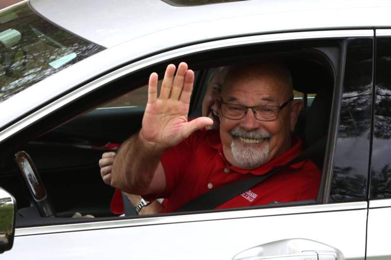 a man in a car waving