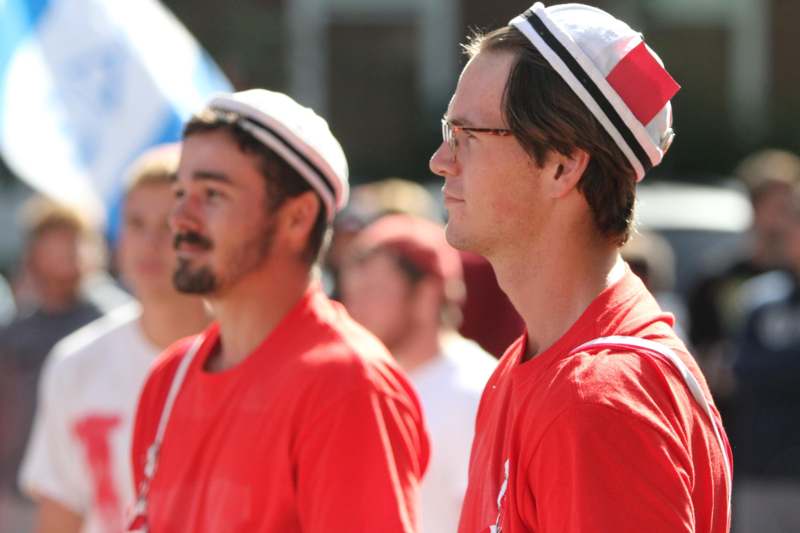 a group of men in red shirts and hats