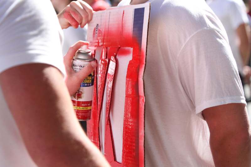a person painting a sign with a spray can