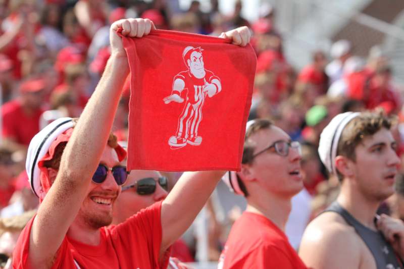 a group of people in red shirts holding up a red cloth