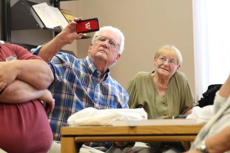 a man taking a selfie with a woman sitting on a table