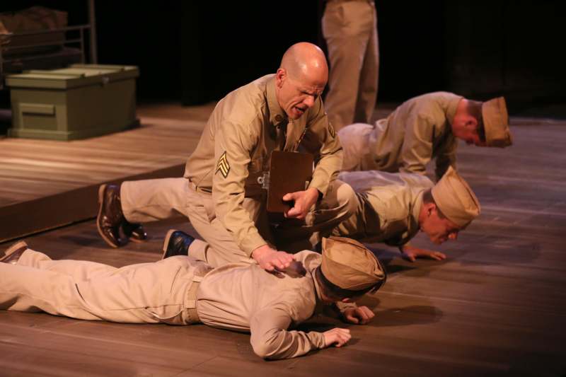 a group of men in tan uniforms on a wooden floor
