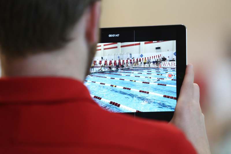 a person holding a tablet with a swimming pool on it