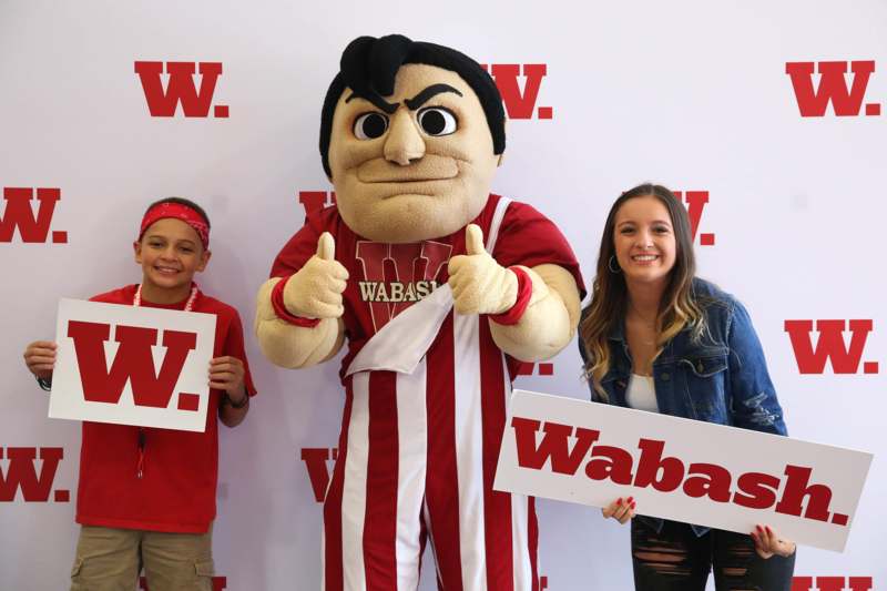 a group of people posing for a picture with a mascot