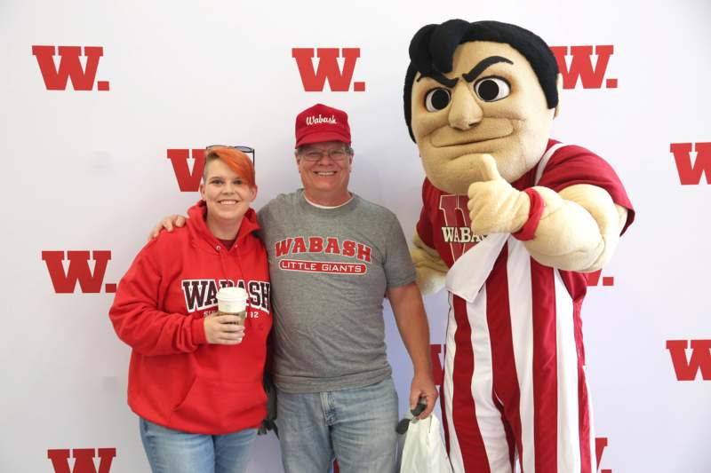 a man and woman posing with a mascot