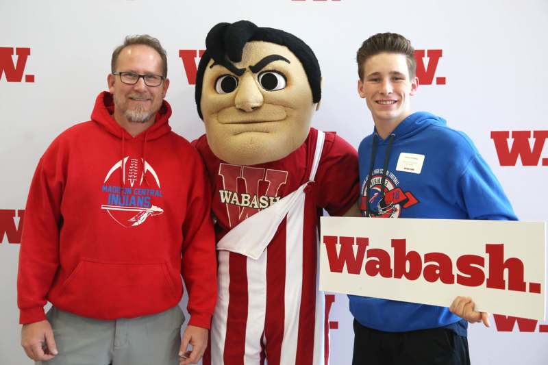 a man and a man posing with a mascot