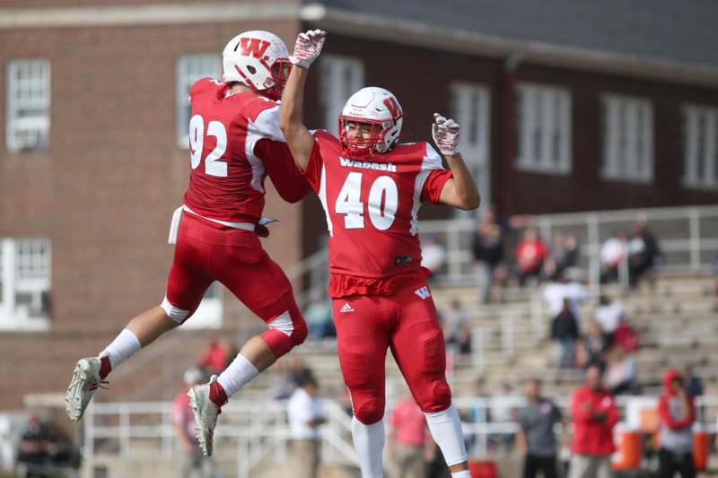 two football players celebrating with their hands in the air