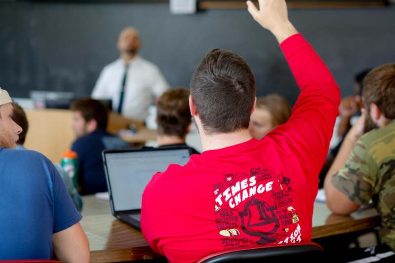 a man raising his hand in a classroom