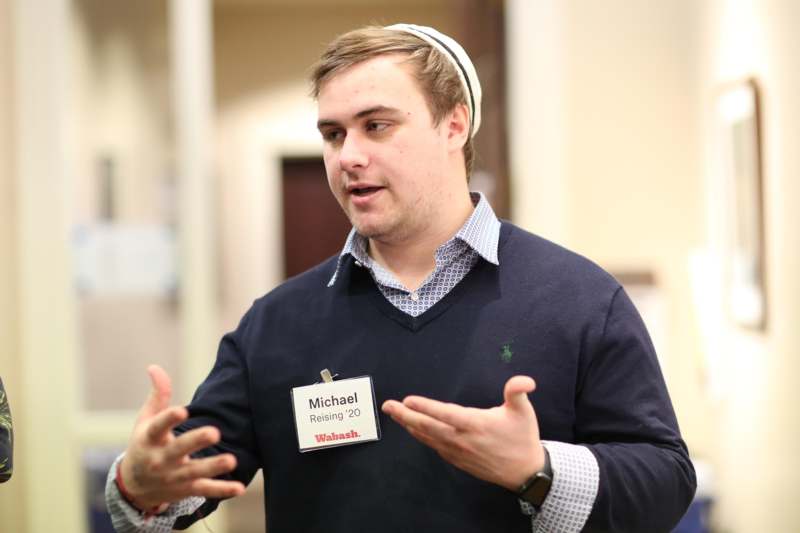 a man wearing a name tag and a sweater