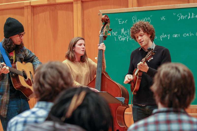 a group of people playing instruments in a classroom