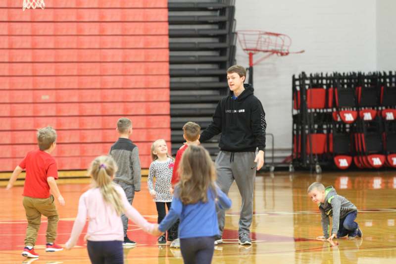 a man standing in a gym with kids